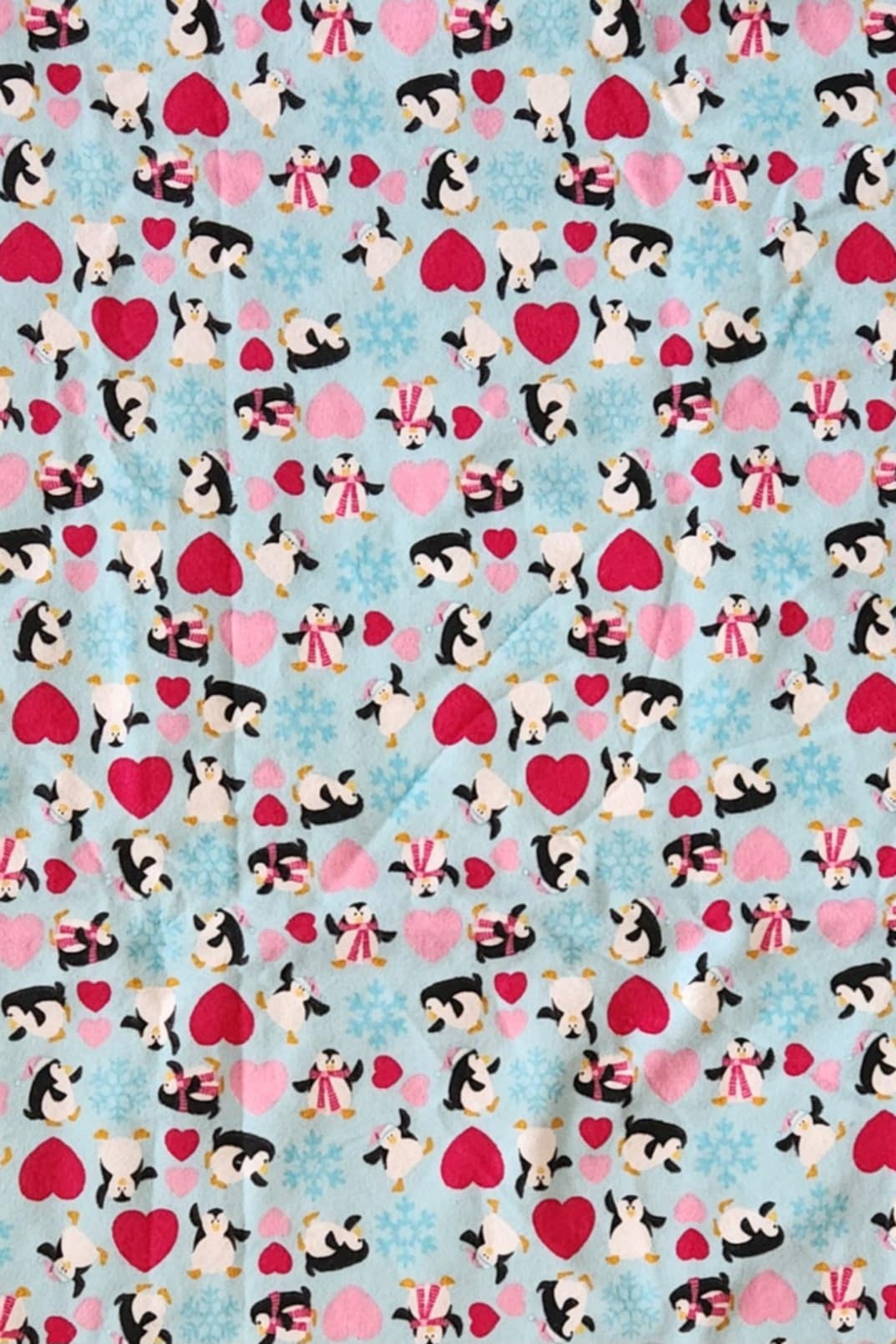 Close up Receiving Blanket with Penguins, red and pink hearts with a blue background Fleece.