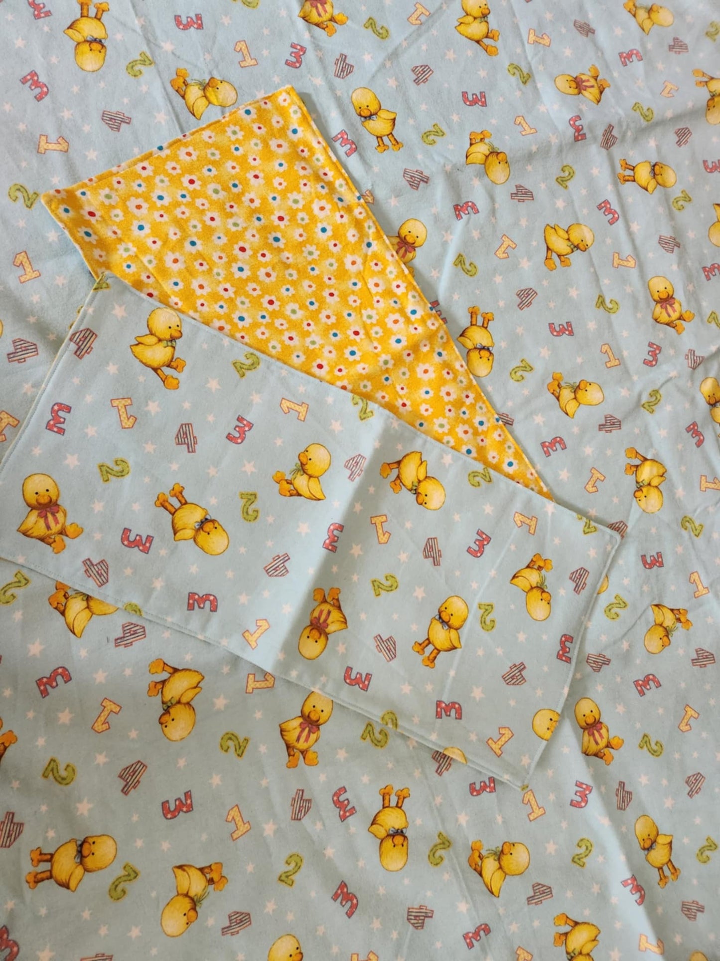 Square Receiving Blanket with Baby ducks and numbers pattern with blue background Fleece. With two burp rags made from the same fabric on top of the blanket