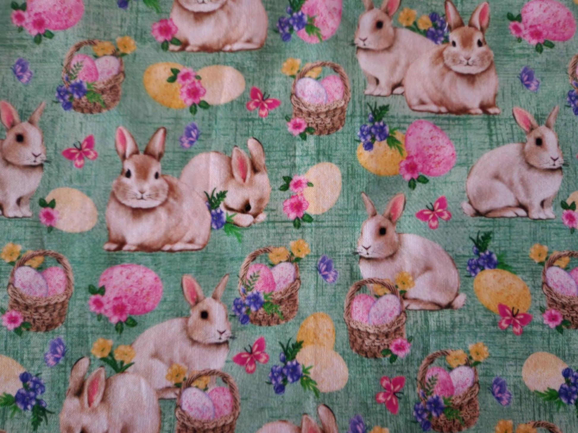 A Close up table runner with bunnies' with baskets filled with Easter eggs  in the middle