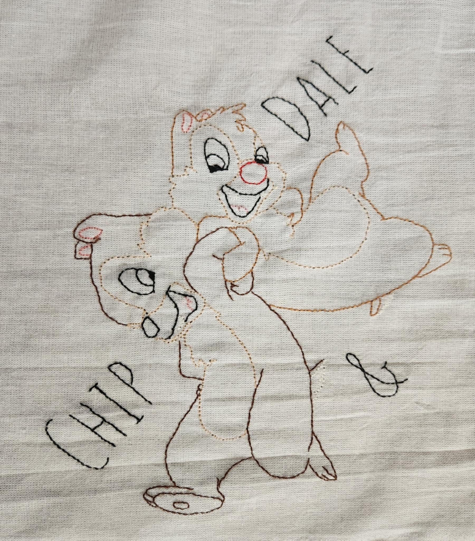 White Dish Towel embroidered  Chipmunks Chip and dale arms entwined. The words " Chip And Dale embroidered in black thread on both sides