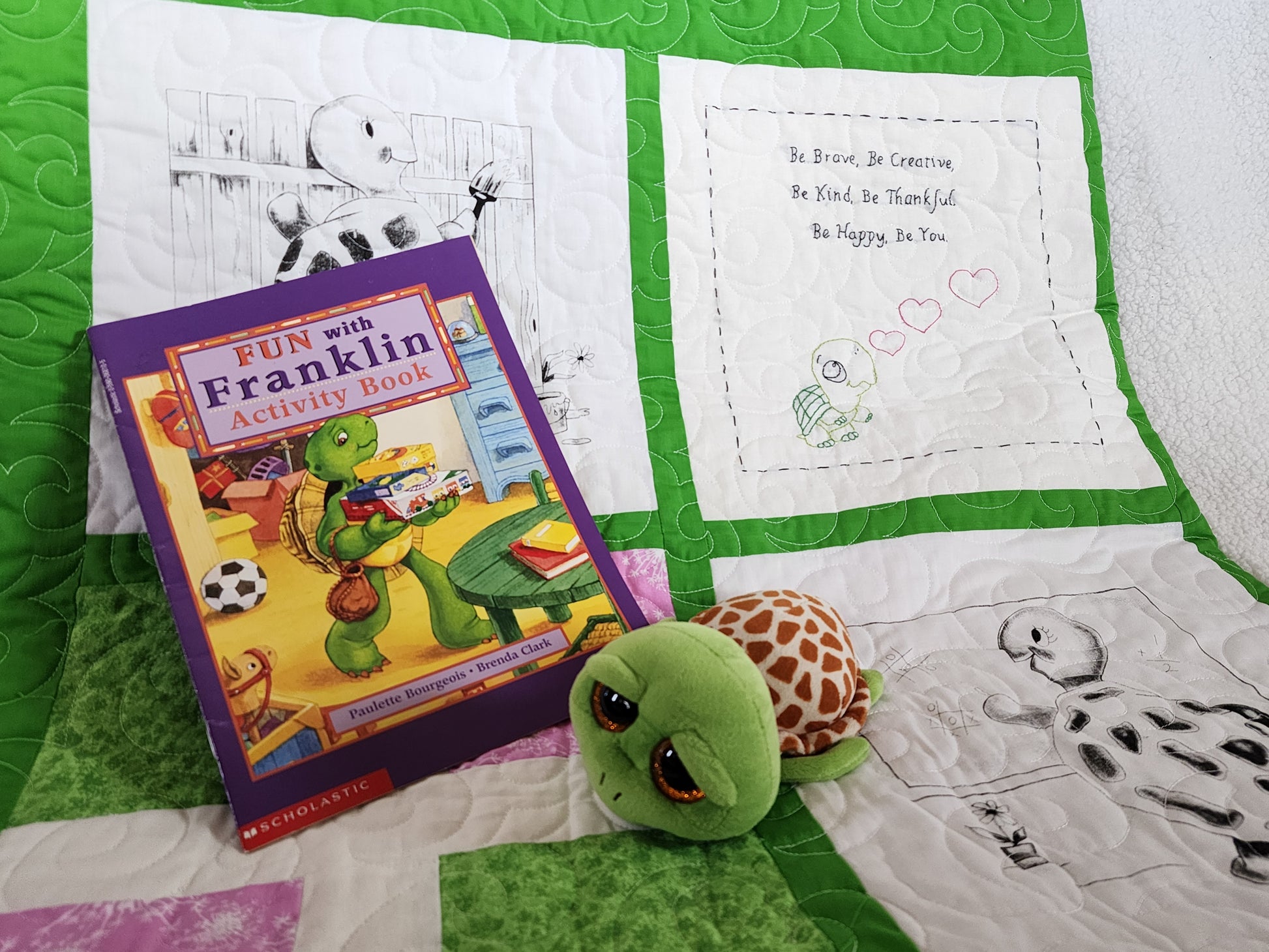 Pink Green and white quilt with a franklin book with a stuff turtle.