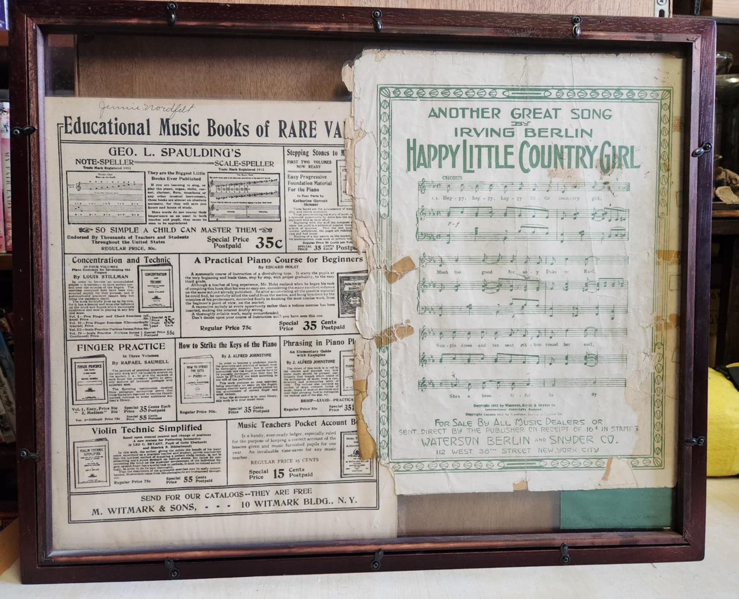 Wood shadow box with a sheet of music and a sheet about music. the sheet music is happy little country girl and the other is educational music books of rare....