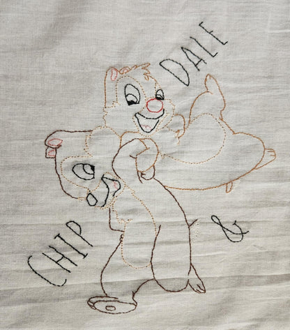 White Dish Towel embroidered  Chipmunks Chip and dale arms entwined. The words " Chip And Dale embroidered in black thread on both sides  