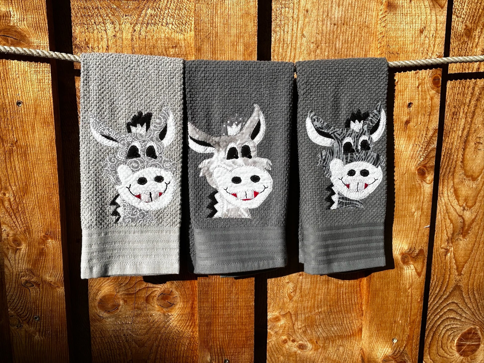 Three hand towels is gray. Each Donkey is gray but have different patterns