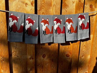 Five Dish towels each one gray. Each fox is red but have different patterns 