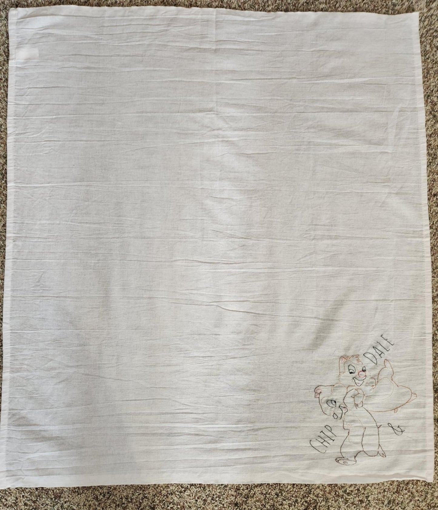 White Square Dish Towel With embroidery in the bottom left corner of Chipmunks Chip and dale arms entwined. The words " Chip And Dale embroidered in black thread on both sides  