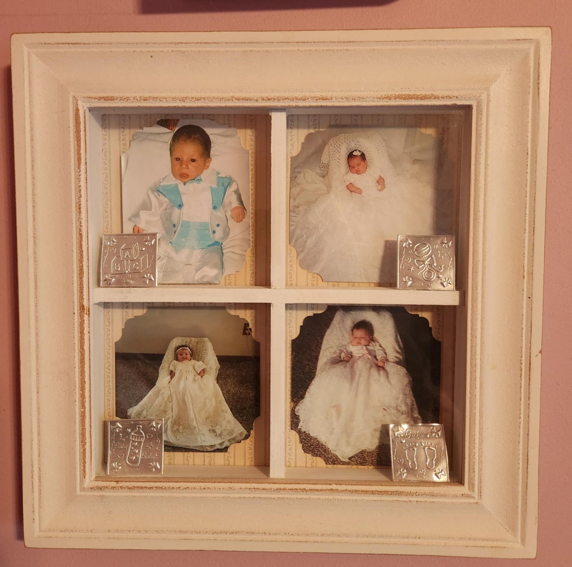 White wood shadow box split into four with a photo of a child in each one