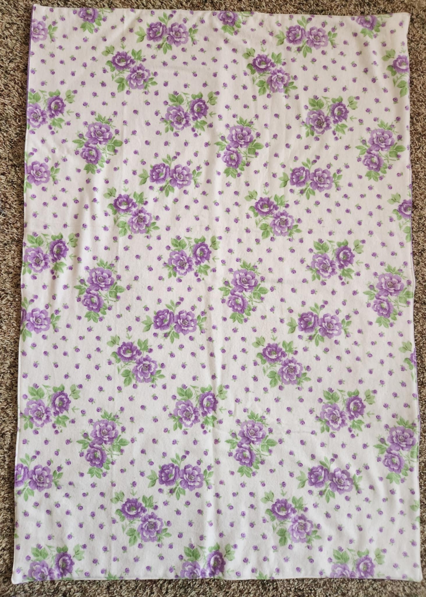 Rectangle Receiving Blanket with purple flowers with green leaves and purple dots with white background. 
